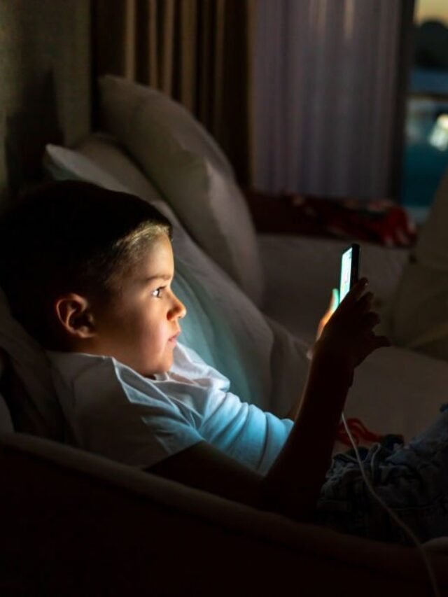 Mother with boy using laptop and smartphone.